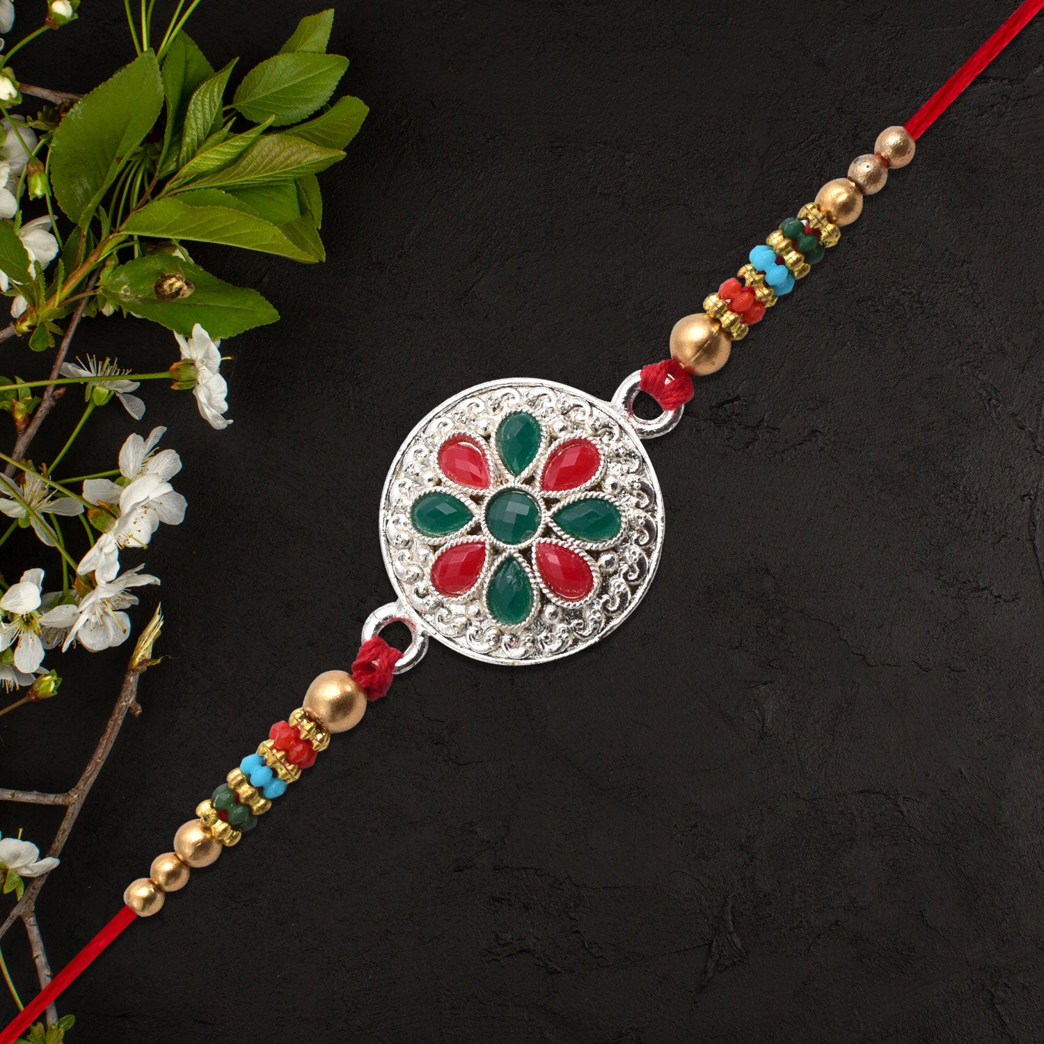 Silver Plated Floral Rakhi With Red  Green Stones Silver Plated Floral Rakhi With Red  Green Stones
